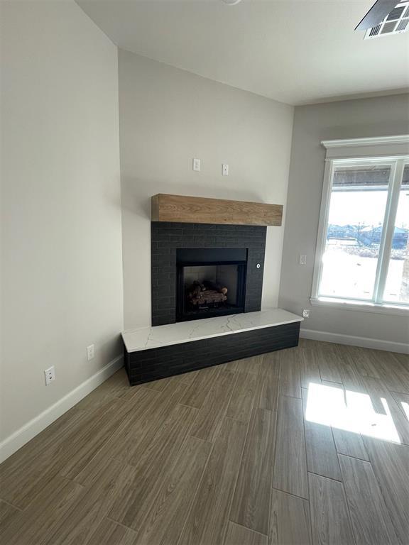 details featuring hardwood / wood-style flooring and a brick fireplace