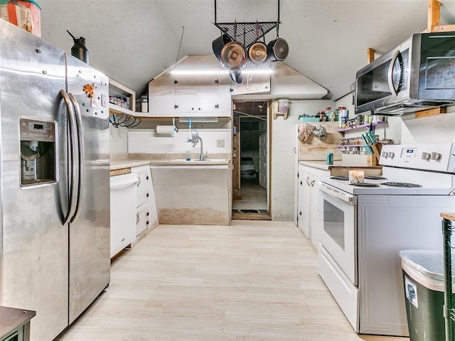 kitchen featuring white electric range oven, stainless steel fridge with ice dispenser, white cabinetry, and sink