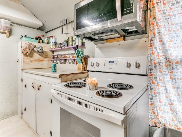 kitchen with white cabinets and white electric range