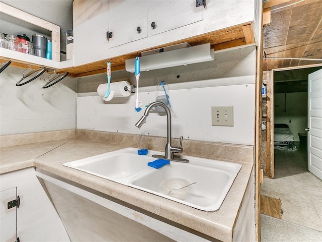 kitchen featuring white cabinetry and sink