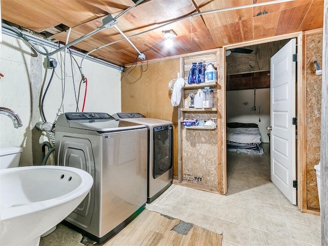 laundry area featuring separate washer and dryer, wooden ceiling, and sink