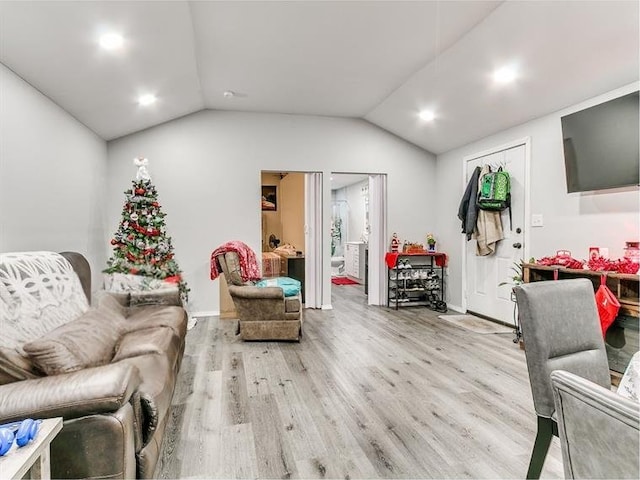 living room with light hardwood / wood-style floors and vaulted ceiling