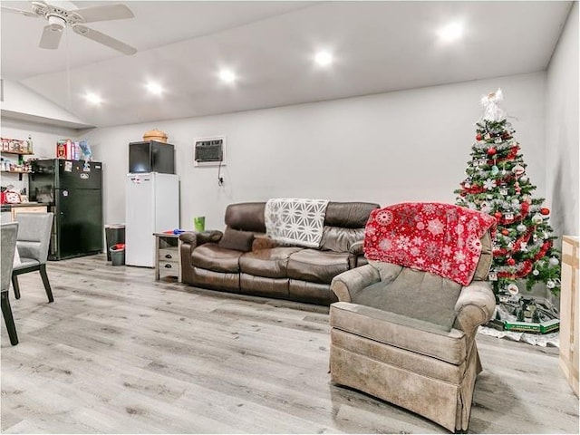 living room with an AC wall unit, ceiling fan, light hardwood / wood-style flooring, and vaulted ceiling