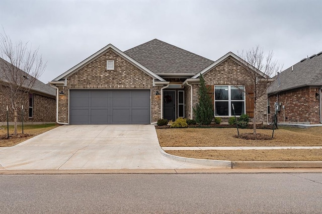 24 Carat Dr, Yukon, OK 73099 - view of front of home featuring driveway, a garage, brick siding, and a front yard