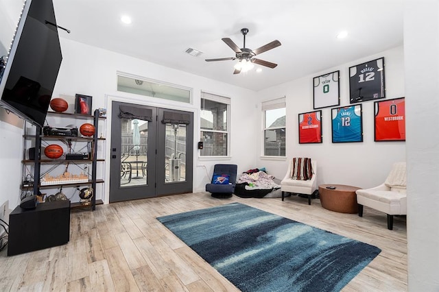 sitting room featuring wood-type flooring, french doors, and ceiling fan