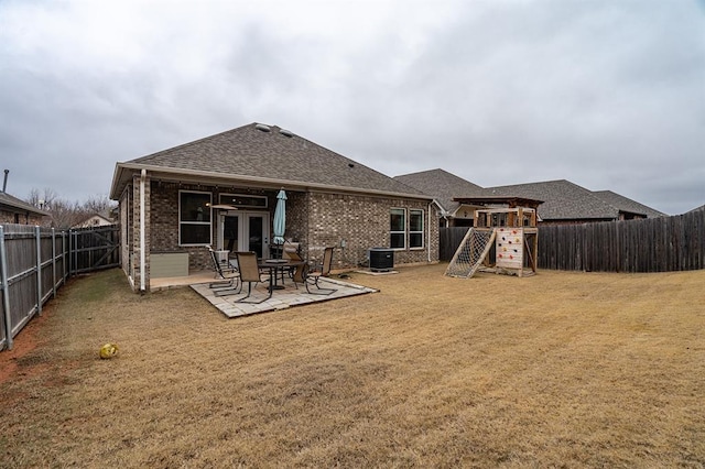 24 Carat Dr, Yukon, OK 73099 - back of property with a playground, brick siding, roof with shingles, a patio, and a fenced backyard
