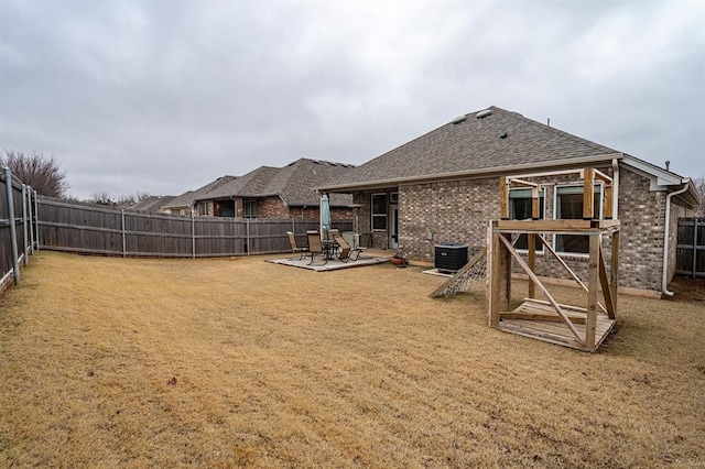 24 Carat Dr, Yukon, OK 73099 - back of property with a fenced backyard, a patio, brick siding, and roof with shingles