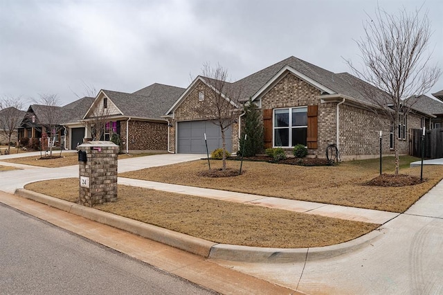 24 Carat Dr, Yukon, OK 73099 - view of front of property with driveway, a garage, brick siding, and roof with shingles