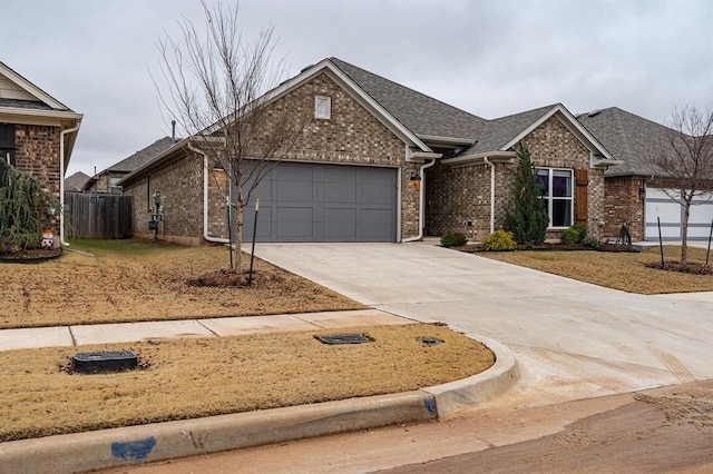 24 Carat Dr, Yukon, OK 73099 - view of front of property with brick siding, a garage, driveway, and roof with shingles