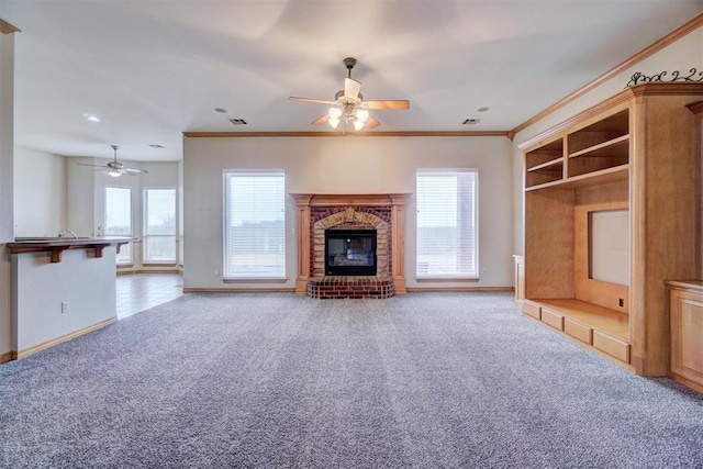 unfurnished living room with carpet, a fireplace, ornamental molding, and ceiling fan