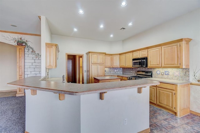 kitchen featuring light brown cabinets, stainless steel appliances, a kitchen breakfast bar, kitchen peninsula, and decorative backsplash