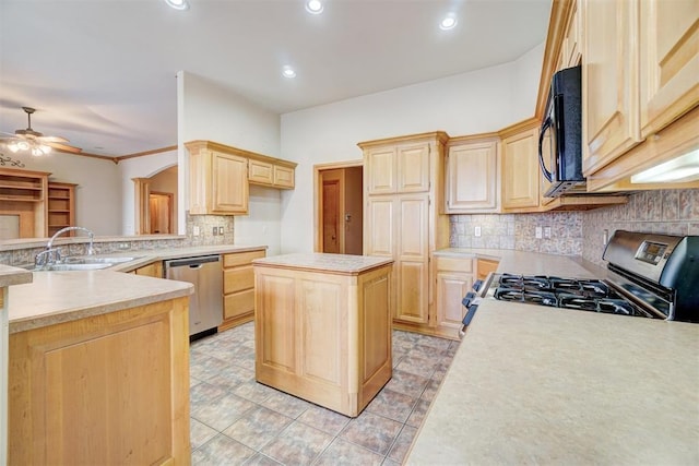 kitchen with appliances with stainless steel finishes, light brown cabinetry, ceiling fan, sink, and a kitchen island