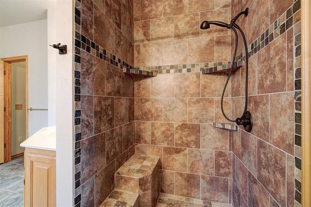 bathroom featuring a tile shower and vanity