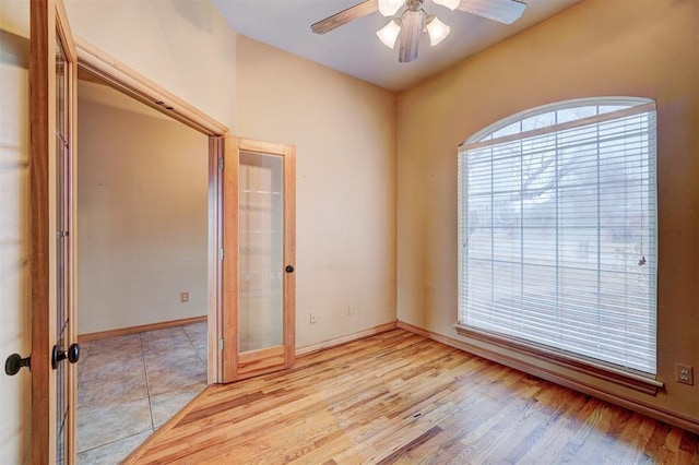 unfurnished room with ceiling fan, french doors, and light hardwood / wood-style flooring