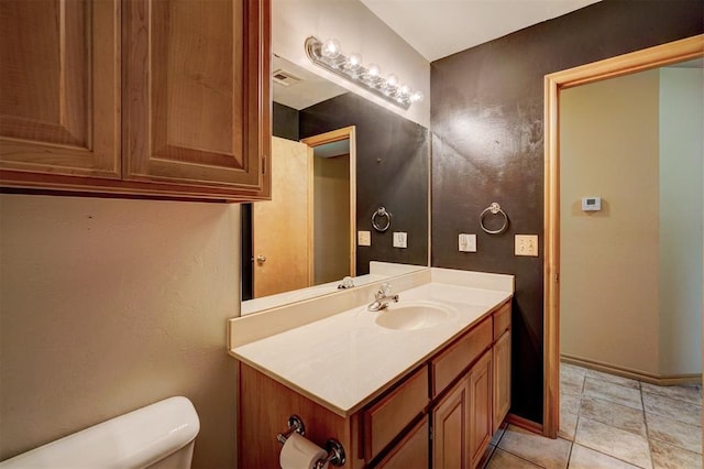 bathroom with tile patterned flooring, vanity, and toilet