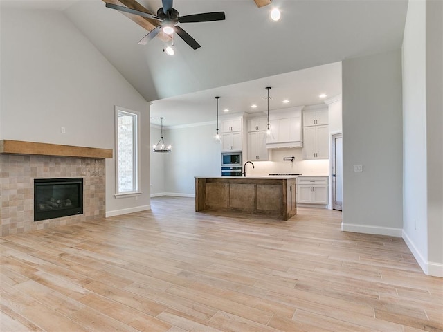 kitchen with white cabinets, a large island, appliances with stainless steel finishes, and decorative light fixtures