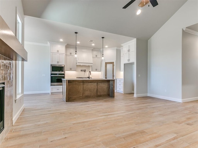 kitchen featuring ceiling fan, a large island, decorative light fixtures, white cabinets, and appliances with stainless steel finishes