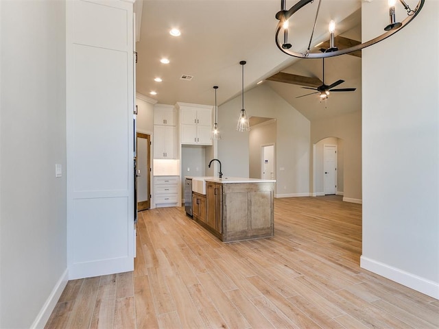 kitchen with dishwasher, a kitchen island with sink, ceiling fan, light hardwood / wood-style floors, and white cabinetry