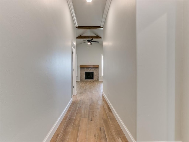 hallway featuring vaulted ceiling with beams, ornamental molding, and light hardwood / wood-style flooring