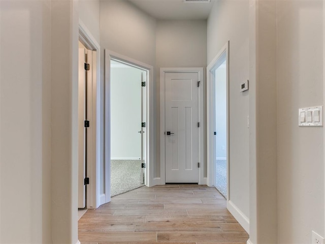 corridor with light hardwood / wood-style flooring