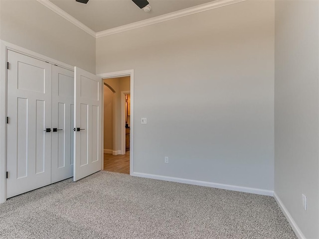 unfurnished bedroom with carpet flooring, ceiling fan, ornamental molding, and a closet