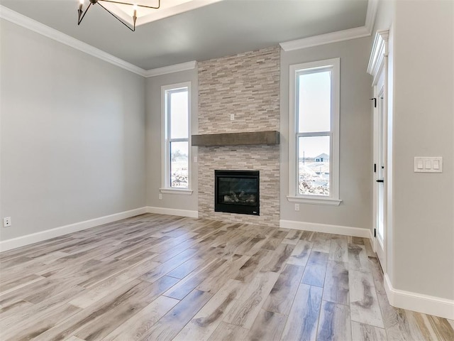 unfurnished living room with light hardwood / wood-style floors, a stone fireplace, and crown molding