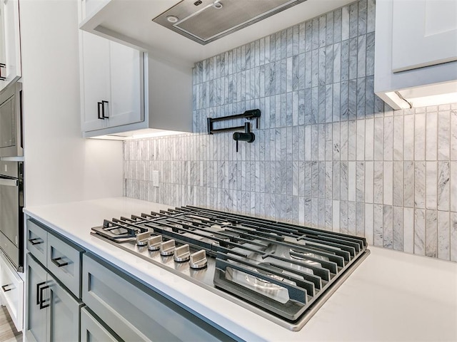 kitchen with white cabinets, stainless steel appliances, and tasteful backsplash