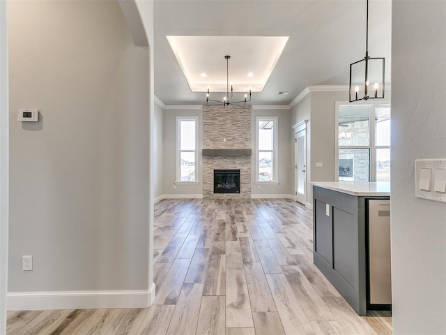 kitchen with a stone fireplace, pendant lighting, and a chandelier