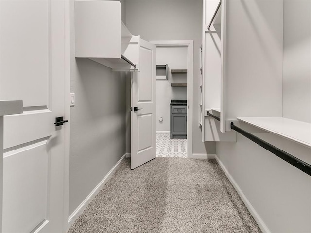 walk in closet featuring light colored carpet