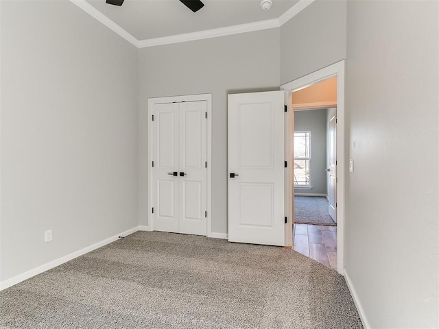 unfurnished bedroom with ceiling fan, carpet floors, ornamental molding, and a closet