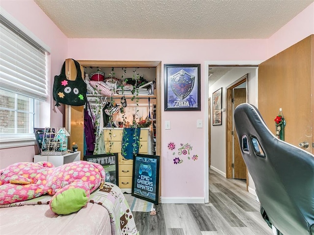 bedroom featuring light wood-type flooring and a textured ceiling