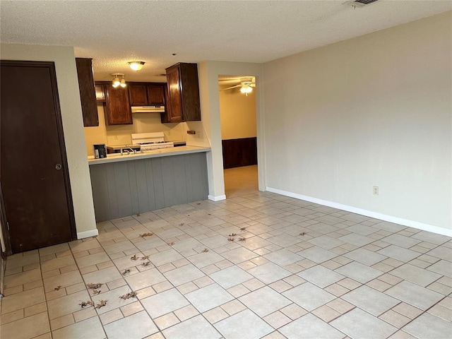 kitchen with kitchen peninsula, a textured ceiling, and white range with gas cooktop