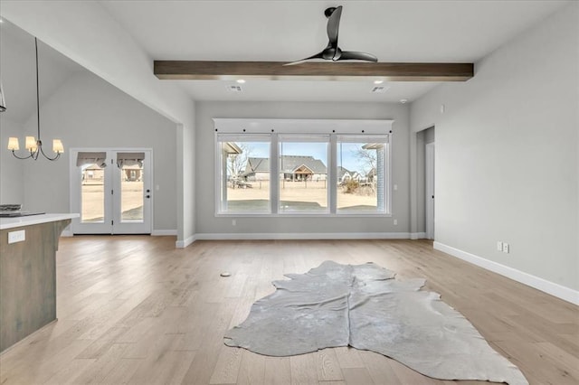 unfurnished living room featuring beam ceiling, light hardwood / wood-style flooring, and ceiling fan with notable chandelier