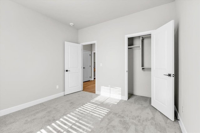 unfurnished bedroom with a closet and light colored carpet