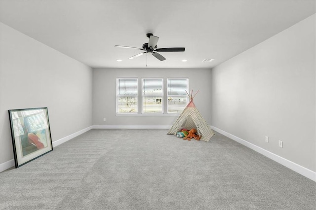 game room featuring light colored carpet and ceiling fan