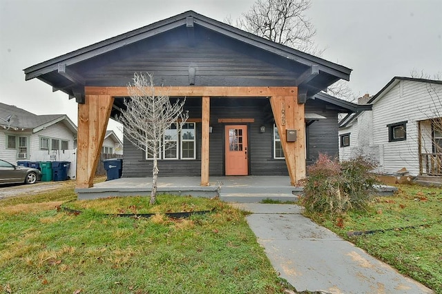 bungalow-style house with covered porch and a front lawn