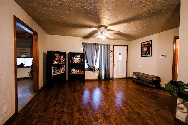 interior space featuring ceiling fan, dark hardwood / wood-style flooring, and a textured ceiling