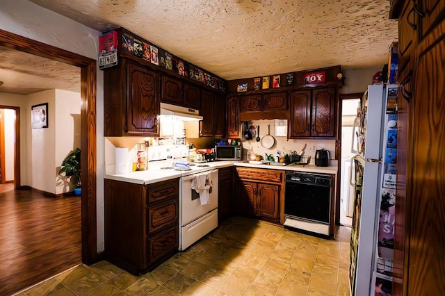 kitchen featuring a textured ceiling, dark brown cabinets, white appliances, and sink