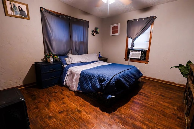 bedroom with ceiling fan, cooling unit, and dark wood-type flooring