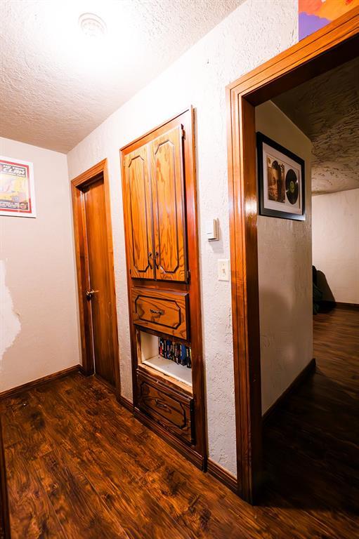 hall with dark hardwood / wood-style flooring and a textured ceiling