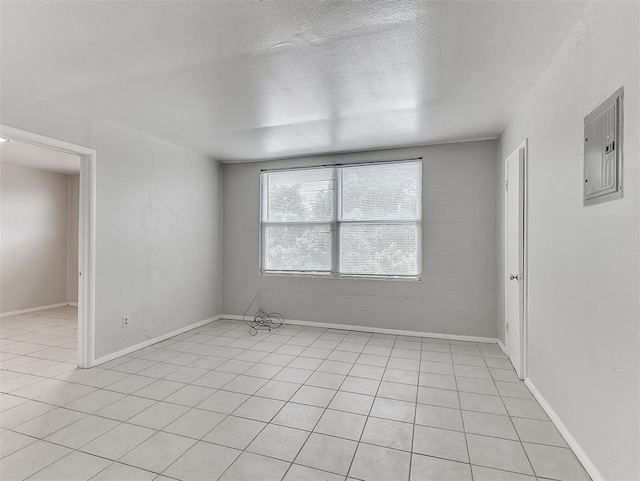 tiled empty room with electric panel and a textured ceiling