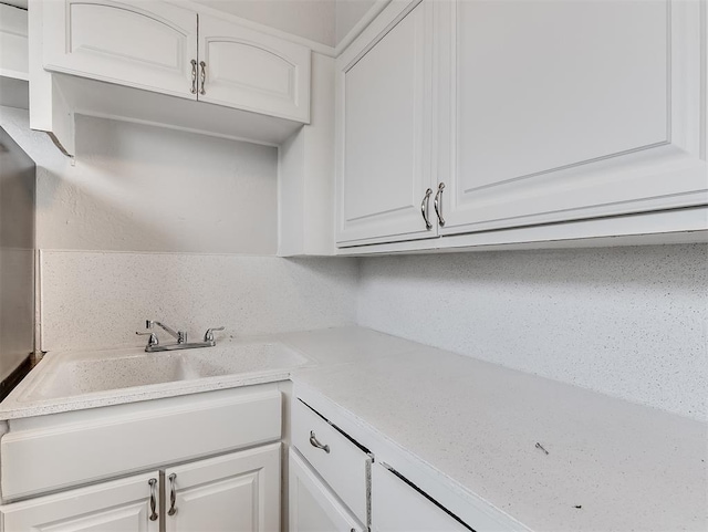 kitchen with sink, white cabinets, and decorative backsplash