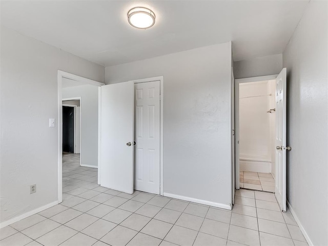 unfurnished bedroom featuring light tile patterned floors and a closet