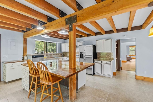 49900 W 201st St, Depew, OK 74028 - kitchen featuring stainless steel appliances, decorative backsplash, light tile patterned flooring, beam ceiling, and a center island