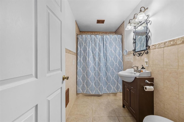 bathroom featuring a shower with shower curtain, vanity, tile walls, and tile patterned flooring