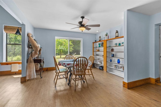 dining area with light wood-type flooring and ceiling fan