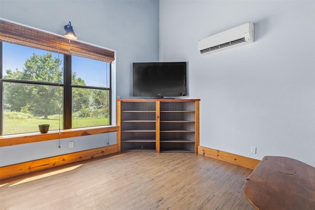 interior space featuring a wall mounted air conditioner and hardwood / wood-style flooring