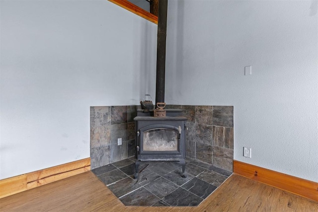 room details featuring a wood stove and wood-type flooring