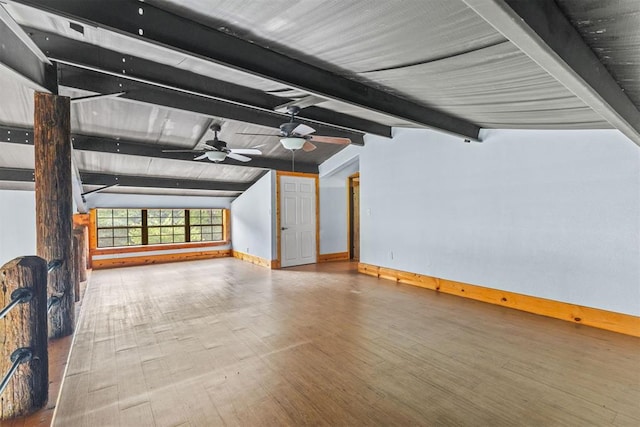 unfurnished living room with hardwood / wood-style floors, lofted ceiling with beams, and ceiling fan