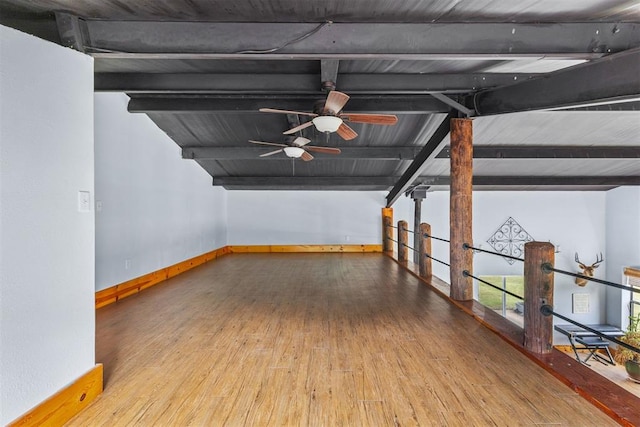 interior space featuring hardwood / wood-style flooring, ceiling fan, and lofted ceiling with beams